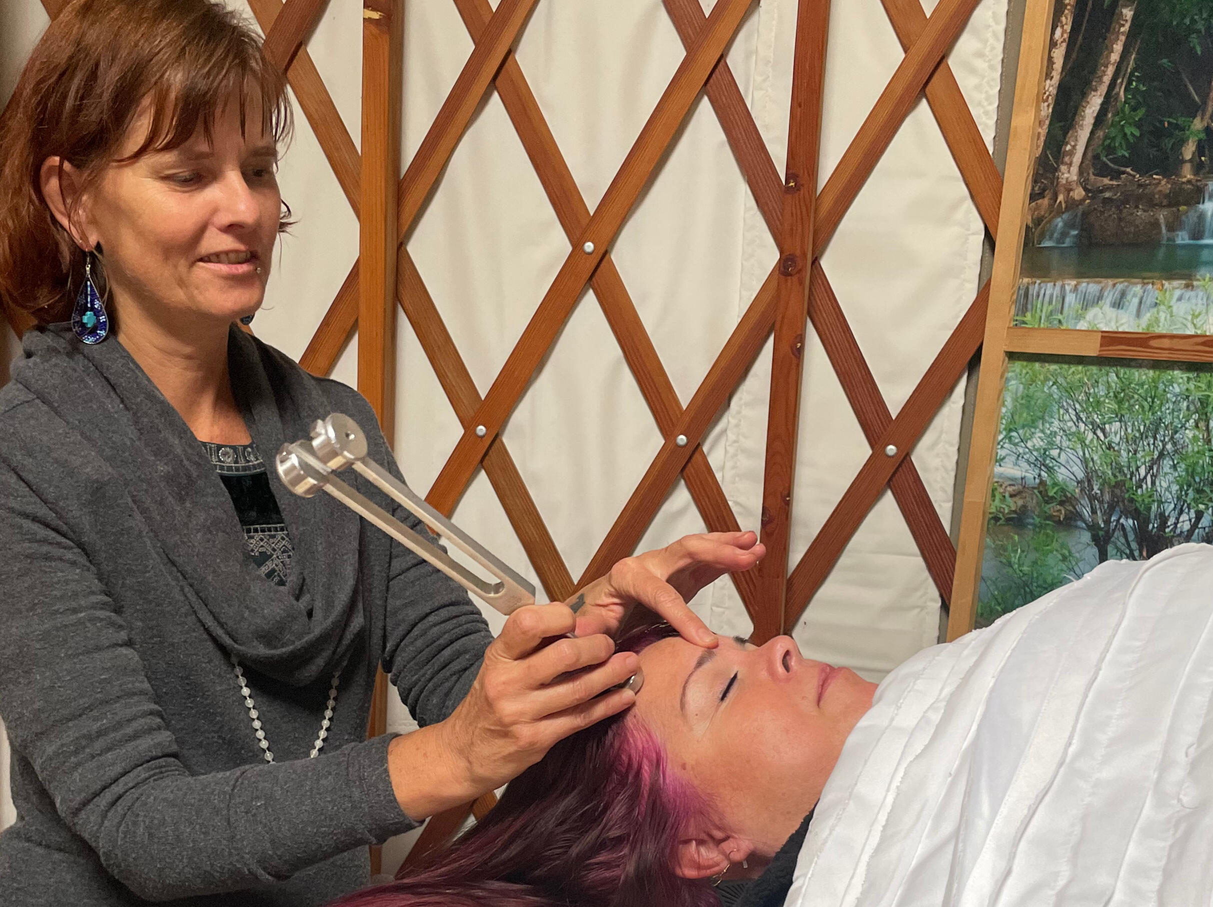 Applying a weighted fork to acupressure points along the hairline
